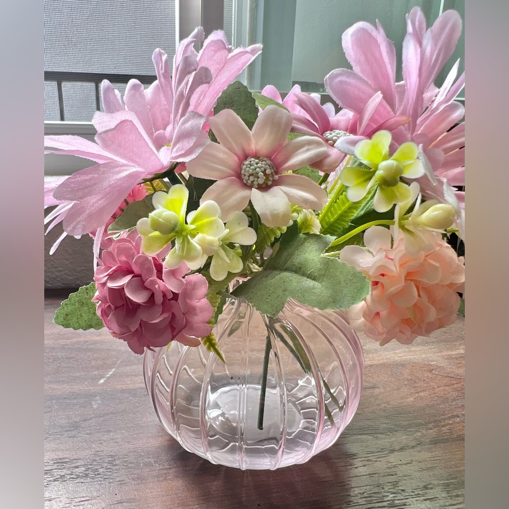 Faux flowers pink in pink glass vase